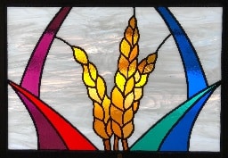 Stained glass window with golden wheat sheaves